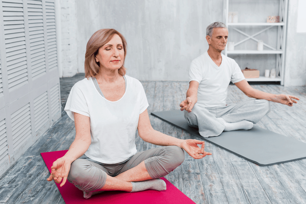 couple meditating on yoga mats