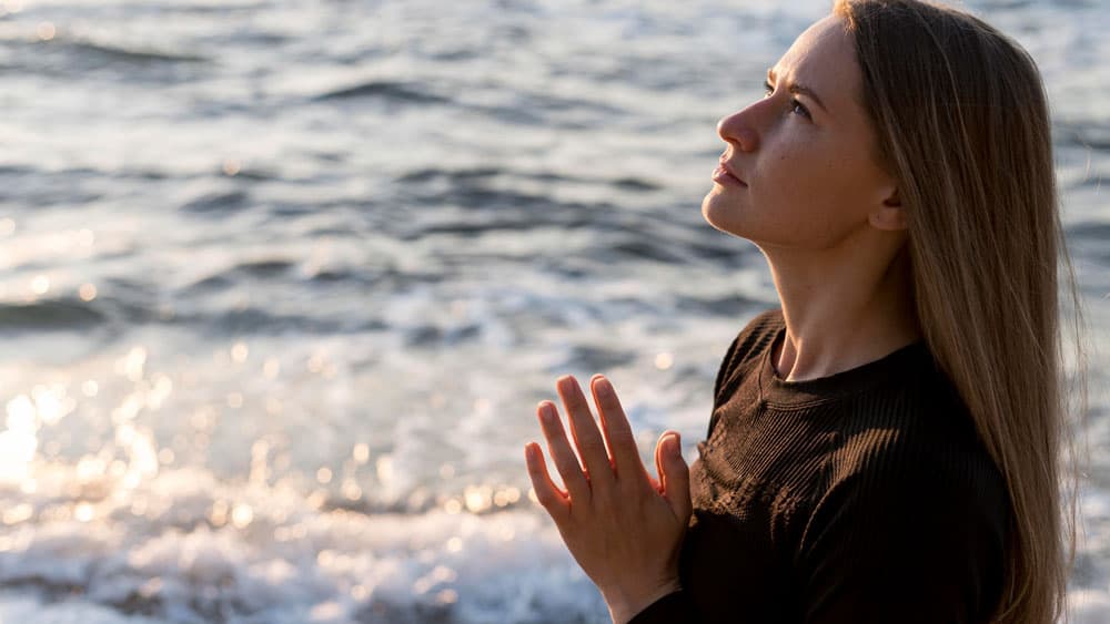 sideways-woman-meditating-beach