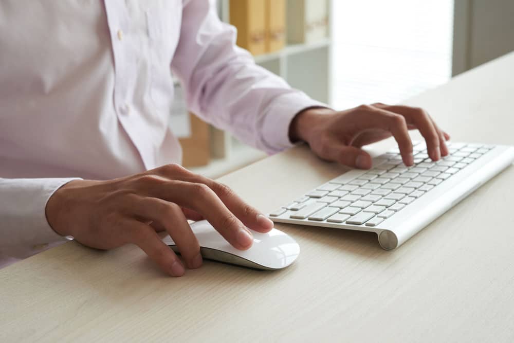 cropped-anonymous-man-computing-white-keyboard-using-white-mouse