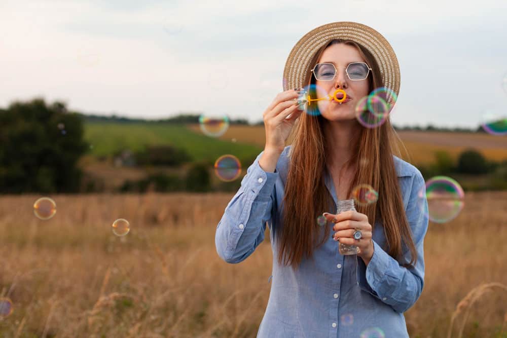 front-view-woman-blowing-bubbles-outdoors-nature